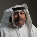 About Portrait of a middle-aged Arabic man in traditional attire with a neutral background.